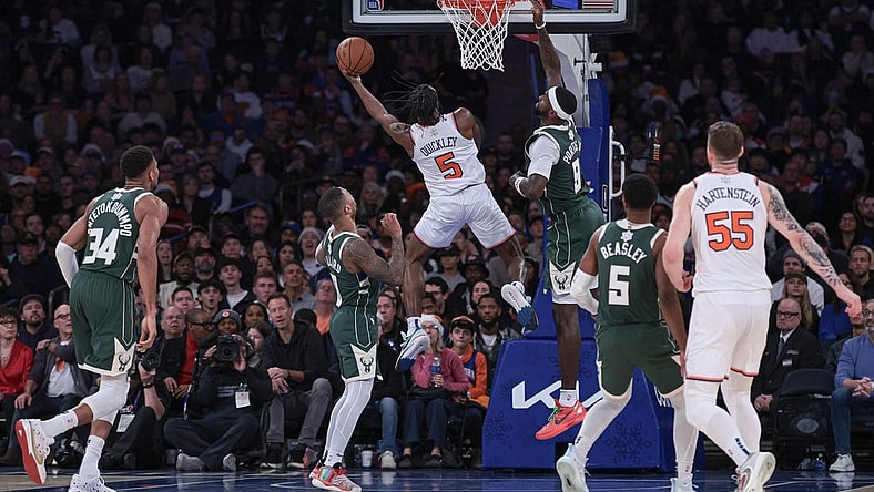 Dec 25, 2023; New York, New York, USA; New York Knicks guard Immanuel Quickley (5) drives to the basket as Milwaukee Bucks forward Bobby Portis (9) and guard Damian Lillard (0) defend during the second half at Madison Square Garden. Mandatory Credit: Vincent Carchietta-USA TODAY Sports