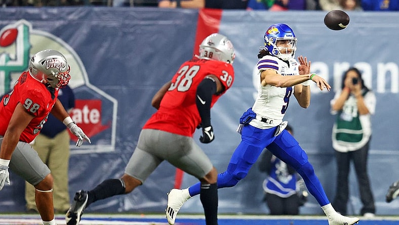 Dec 26, 2023; Phoenix, AZ, USA; Kansas Jayhawks quarterback Jason Bean (9) throws a pass against UNLV Rebels linebacker Marsel McDuffie (38) during the first quarter in the Guaranteed Rate Bowl at Chase Field. Mandatory Credit: Mark J. Rebilas-USA TODAY Sports