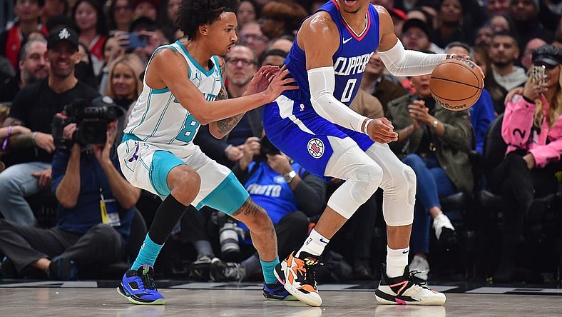 Dec 26, 2023; Los Angeles, California, USA; Los Angeles Clippers guard Russell Westbrook (0) moves the ball against Charlotte Hornets guard Nick Smith Jr. (8) during the first half at Crypto.com Arena. Mandatory Credit: Gary A. Vasquez-USA TODAY Sports