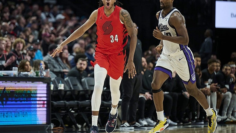 Dec 26, 2023; Portland, Oregon, USA; Portland Trail Blazers forward Jabari Walker (34) celebrates making a three point basket during the second half against Sacramento Kings forward Harrison Barnes (40) at Moda Center. Mandatory Credit: Troy Wayrynen-USA TODAY Sports