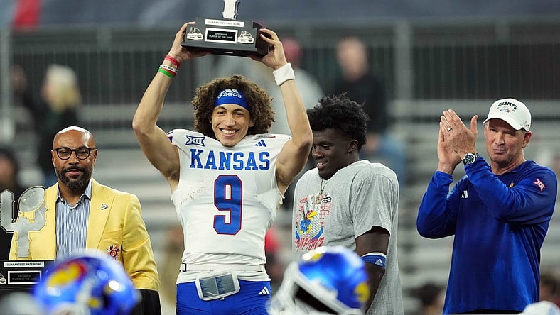 Dec 26, 2023; Phoenix, AZ, USA; Kansas Jayhawks quarterback Jason Bean (9) celebrates with the trophy after defeating the UNLV Rebels at Chase Field. Mandatory Credit: Joe Camporeale-USA TODAY Sports