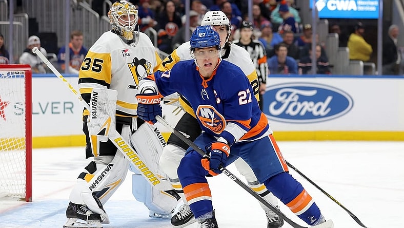Dec 27, 2023; Elmont, New York, USA; New York Islanders left wing Anders Lee (27) skates against Pittsburgh Penguins goaltender Tristan Jarry (35) and defenseman Ryan Graves (27) during the second period at UBS Arena. Mandatory Credit: Brad Penner-USA TODAY Sports