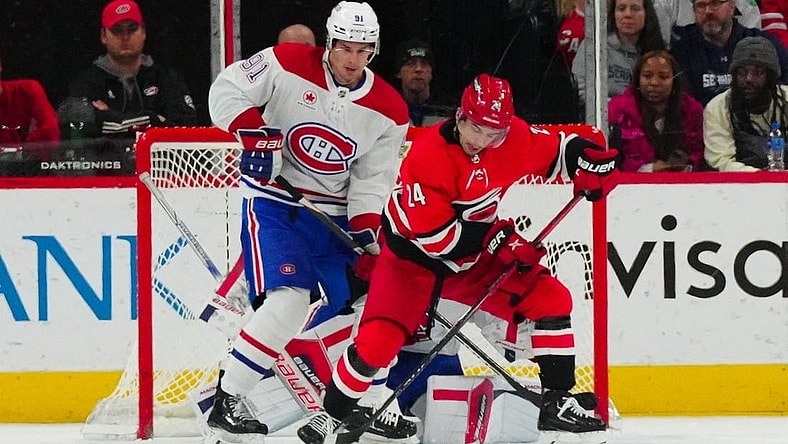 Dec 28, 2023; Raleigh, North Carolina, USA; Carolina Hurricanes center Seth Jarvis (24) and Montreal Canadiens center Sean Monahan (91) watch the shot during the second period at PNC Arena. Mandatory Credit: James Guillory-USA TODAY Sports
