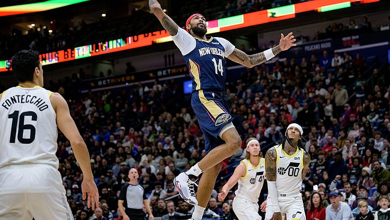 Dec 28, 2023; New Orleans, Louisiana, USA; New Orleans Pelicans forward Brandon Ingram (14) dunks against Utah Jazz guard Jordan Clarkson (00) during the first quarter at the Smoothie King Center. Mandatory Credit: Matthew Hinton-USA TODAY Sports