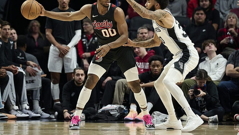 Dec 29, 2023; Portland, Oregon, USA; Portland Trail Blazers guard Scoot Henderson (00) looks to pass the ball during the first half against San Antonio Spurs forward Julian Champagnie (30) at Moda Center. Mandatory Credit: Troy Wayrynen-USA TODAY Sports