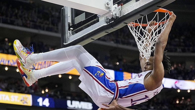 Dec 30, 2023; Kansas City, Missouri, USA; Kansas Jayhawks guard Elmarko Jackson (13) dunks against Wichita State Shockers center Quincy Ballard (15) and guard Bijan Cortes (55) during the first half at T-Mobile Center. Mandatory Credit: Jay Biggerstaff-USA TODAY Sports