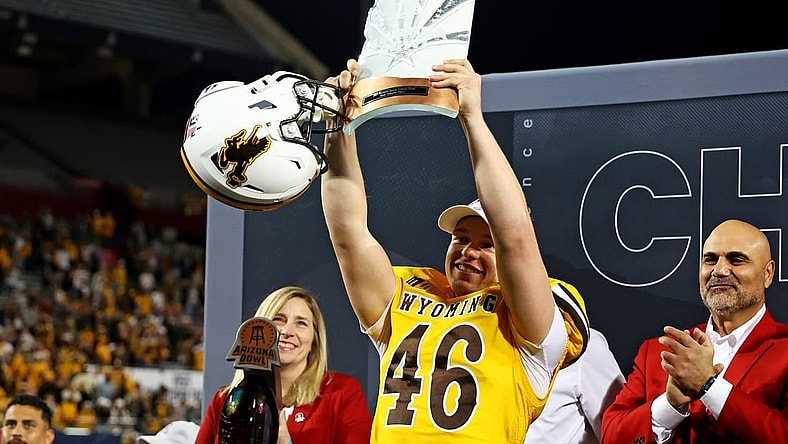 Dec 30, 2023; Tucson, AZ, USA; Wyoming Cowboys place kicker John Hoyland (46) celebrates with offensive MVP trophy after the Wyoming Cowboys beat the Toledo Rockets in the Arizona Bowl at Arizona Stadium. Mandatory Credit: Mark J. Rebilas-USA TODAY Sports