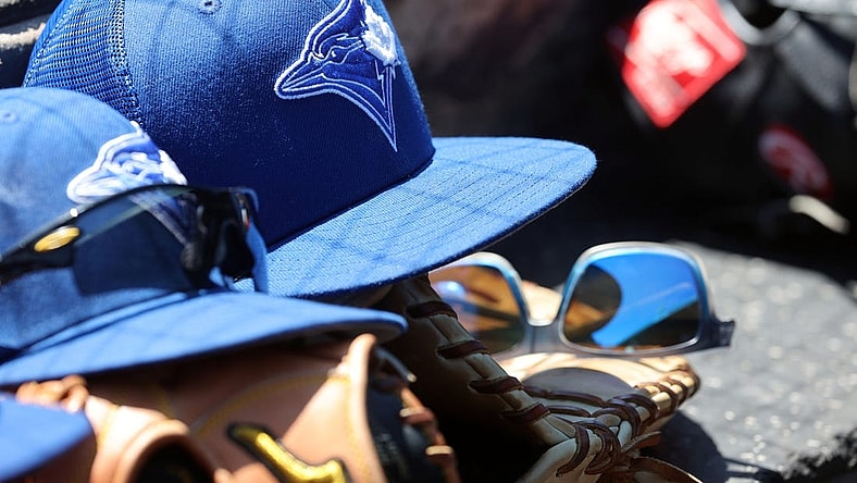 Mar 18, 2022; Sarasota, Florida, USA; A detail view of a Toronto Blue Jays hat and glove in the dugout during spring training against the Baltimore Orioles at Ed Smith Stadium. Mandatory Credit: Kim Klement-USA TODAY Sports