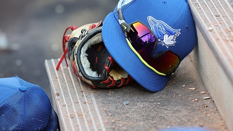 Mar 25, 2023; Dunedin, Florida, USA;  A detail view of Toronto Blue Jays hat and glove against the Detroit Tigers at TD Ballpark. Mandatory Credit: Kim Klement-USA TODAY Sports