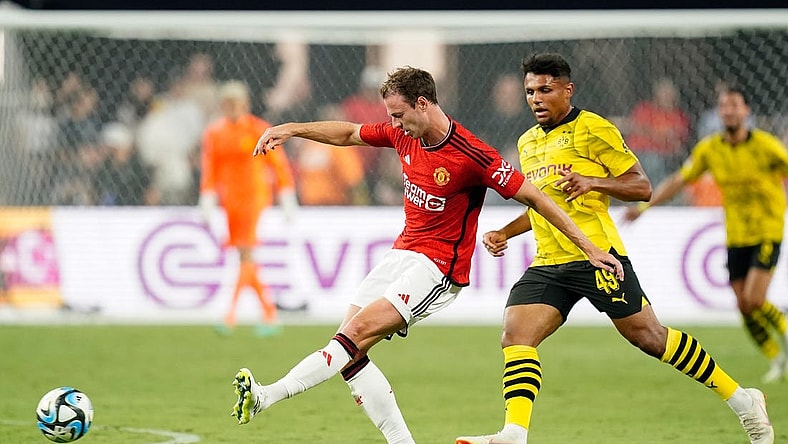 Jul 30, 2023; Las Vegas, Nevada, USA; Manchester United defender Jonny Evans (27) kicks the ball against Borussia Dortmund forward Paul-Phillip Besong (49) during the second half at Allegiant Stadium. Mandatory Credit: Lucas Peltier-USA TODAY Sports