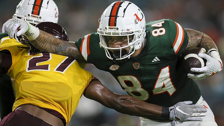 Sep 14, 2023; Miami Gardens, Florida, USA; Miami Hurricanes tight end Cam McCormick (84) runs with the football against Bethune Cookman Wildcats cornerback Stephen Sparrow (27) during the first quarter at Hard Rock Stadium. Mandatory Credit: Sam Navarro-USA TODAY Sports