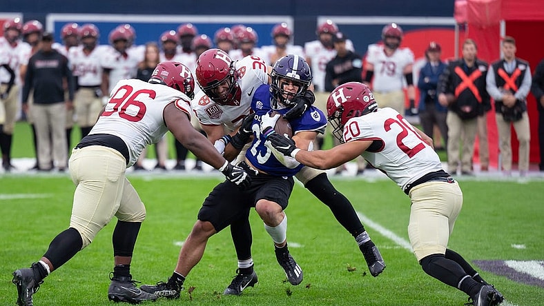 Holy Cross's Jordan Fuller is tackled by a wall of Harvard defenders during Saturday's EBW Football Classic at Polar Park.