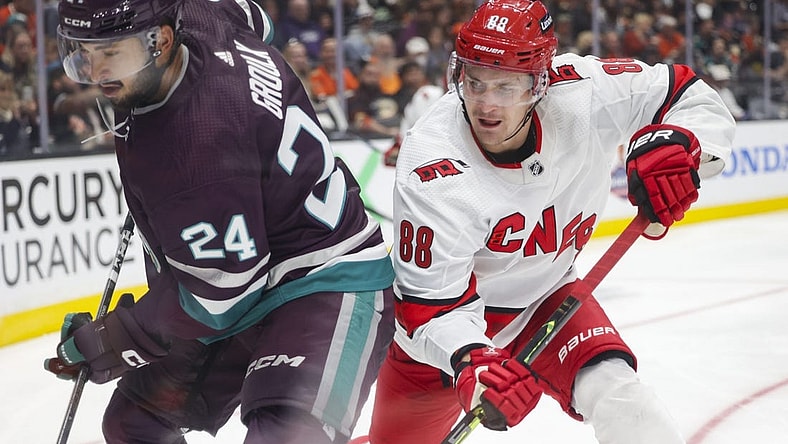 Oct 15, 2023; Anaheim, California, USA; Anaheim Ducks center Bo Groulx (24) makes a play against Carolina Hurricanes defensemen Brent Burns (8) in the third period at Honda Center. Mandatory Credit: Yannick Peterhans-USA TODAY Sports