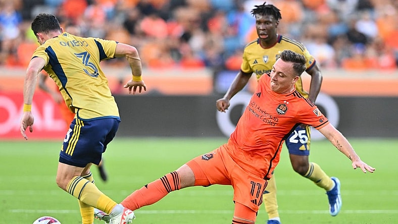 Oct 29, 2023; Houston, TX, USA; Houston Dynamo forward Corey Baird (11) kicks the bal from Real Salt Lake defender Bryan Oviedo (3) in the first half for game one in a round one match of the 2023 MLS Cup Playoffs at Shell Energy Stadium. Mandatory Credit: Maria Lysaker-USA TODAY Sports