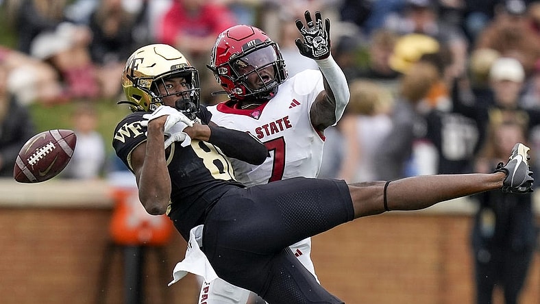 Nov 11, 2023; Winston-Salem, North Carolina, USA; Wake Forest Demon Deacons running back Justice Ellison (6) loses the ball defended by North Carolina State Wolfpack cornerback Shyheim Battle (7) during the first half at Allegacy Federal Credit Union Stadium. Mandatory Credit: Jim Dedmon-USA TODAY Sports
