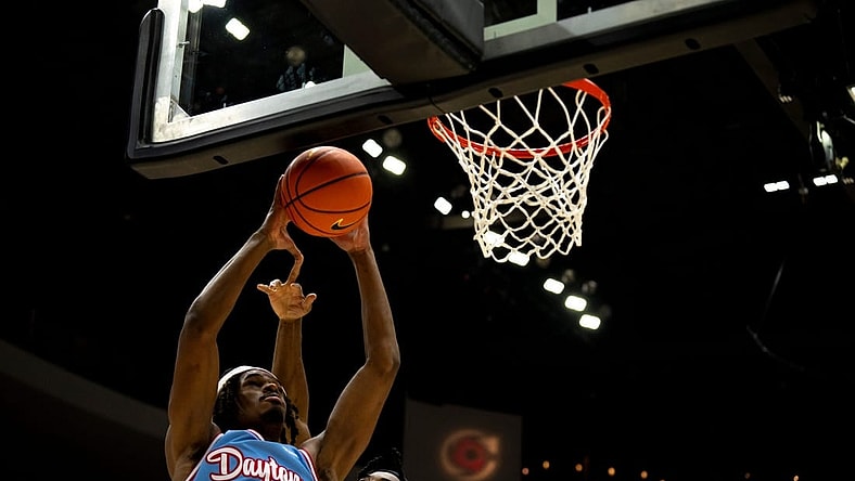 Dayton Flyers forward DaRon Holmes II (15) draws a foul from Cincinnati Bearcats guard Day Day Thomas (1) in the second half of the NCAA men's basketball game between the Dayton Flyers and Cincinnati Bearcats at Heritage Bank Center in Cincinnati on Saturday, Dec. 16, 2023.