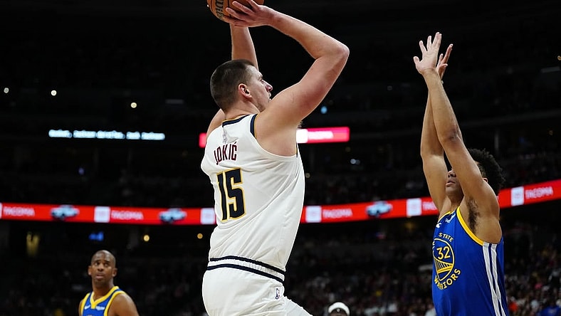 Dec 25, 2023; Denver, Colorado, USA; Denver Nuggets center Nikola Jokic (15) prepares to shoot over Golden State Warriors forward Trayce Jackson-Davis (32) in the second half at Ball Arena. Mandatory Credit: Ron Chenoy-USA TODAY Sports