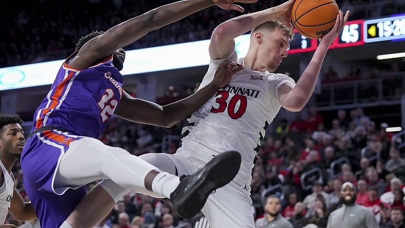 Dec 29, 2023; Cincinnati, Ohio, USA;  Cincinnati Bearcats forward Viktor Lakhin (30) grabs a rebound against Evansville Aces forward Sekou Kalle (22) in the second half at Fifth Third Arena. Mandatory Credit: Aaron Doster-USA TODAY Sports