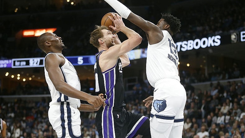 Dec 31, 2023; Memphis, Tennessee, USA; Sacramento Kings forward Domantas Sabonis (10) drives to the basket between Memphis Grizzlies center Bismack Biyombo (18) and forward-center Jaren Jackson Jr. (13) during the first half at FedExForum. Mandatory Credit: Petre Thomas-USA TODAY Sports