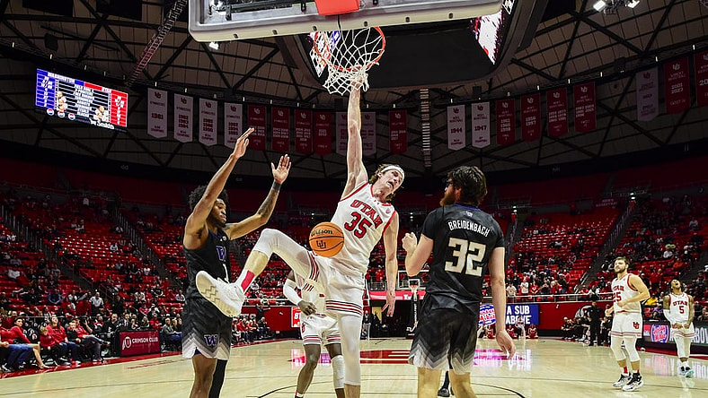Dec 31, 2023; Salt Lake City, Utah, USA; Utah Utes center Branden Carlson (35) hangs onto the basket after dunking over Washington Huskies forward Wilhelm Breidenbach (32) during the second half at the the Jon M. Huntsman Center. Mandatory Credit: Christopher Creveling-USA TODAY Sports