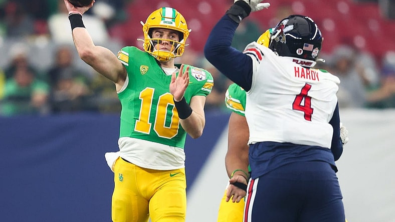 Jan 1, 2024; Glendale, AZ, USA; Oregon Ducks quarterback Bo Nix (10) throws the ball under pressure from Liberty Flames defensive tackle Jay Hardy (4) during the first quarter of the 2024 Fiesta Bowl at State Farm Stadium. Mandatory Credit: Mark J. Rebilas-USA TODAY Sports
