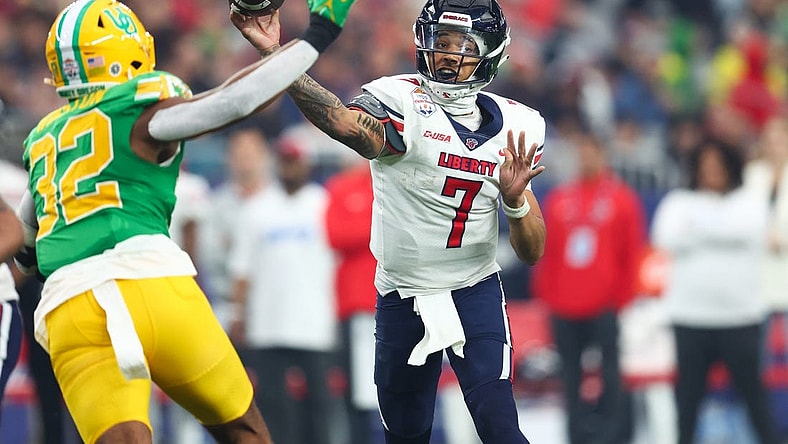 Jan 1, 2024; Glendale, AZ, USA; Liberty Flames quarterback Kaidon Salter (7) throws the ball under pressure from Oregon Ducks linebacker Emar'rion Winston (32) during the second half in the 2024 Fiesta Bowl at State Farm Stadium. Mandatory Credit: Mark J. Rebilas-USA TODAY Sports