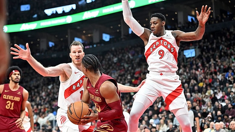 Jan 1, 2024; Toronto, Ontario, CAN; Toronto Raptors center Jakob Poeltl (19) and forward RJ Barrett (9) defend their basket as Cleveland Cavaliers guard Isaac Okoro (35) looks to make a pass in the first half at Scotiabank Arena. Mandatory Credit: Dan Hamilton-USA TODAY Sports