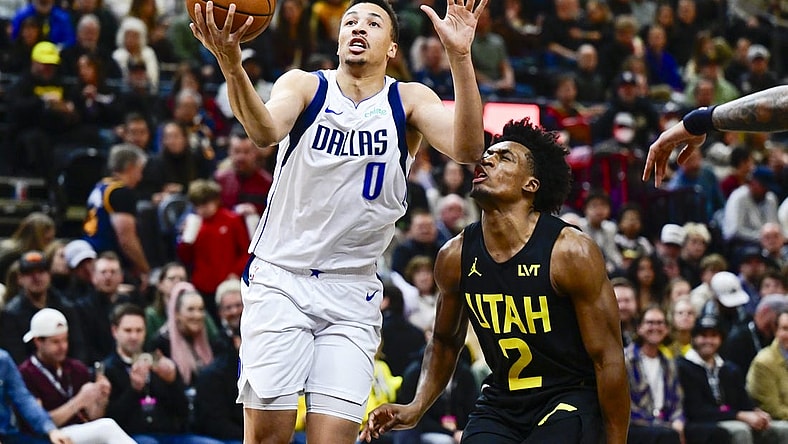 Jan 1, 2024; Salt Lake City, Utah, USA; Dallas Mavericks guard Dante Exum (0) takes a shot in front of Utah Jazz guard Collin Sexton (2) during the first half at the Delta Center. Mandatory Credit: Christopher Creveling-USA TODAY Sports