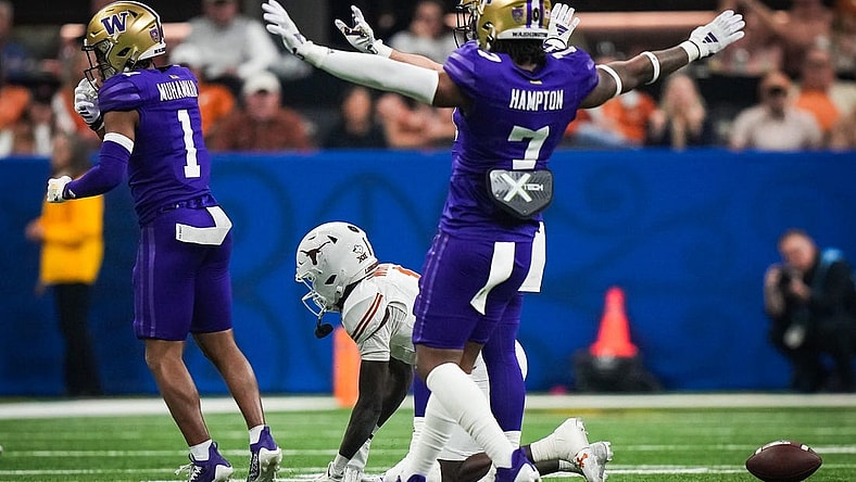 Texas Longhorns wide receiver Xavier Worthy (1) remains on the ground at the Washington Huskies defense, including cornerback Dominique Hampton (7) celebrate stopping a play in the second quarter of the Sugar Bowl College Football Playoff semi-finals at the Ceasars Superdome in New Orleans, Louisiana, Jan. 1, 2024. The Texas Longhorns take on the Washington Huskies for a spot in the College Football Playoff Finals.