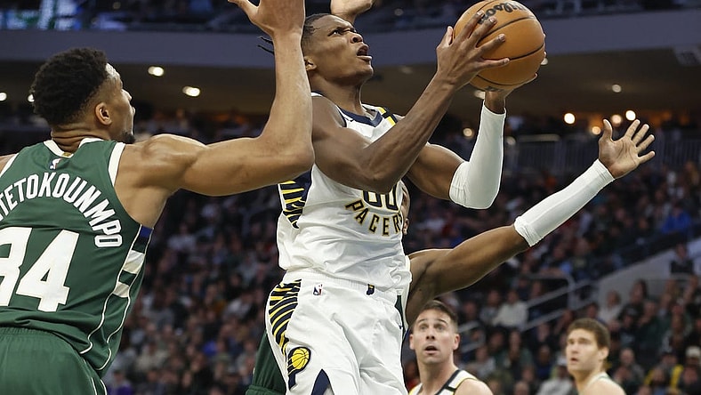Jan 1, 2024; Milwaukee, Wisconsin, USA; Indiana Pacers guard Bennedict Mathurin (00) goes to the basket against Milwaukee Bucks forward Giannis Antetokounmpo (34) during the second half at Fiserv Forum. Mandatory Credit: Kamil Krzaczynski-USA TODAY Sports