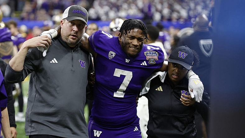 Jan 1, 2024; New Orleans, LA, USA; Washington Huskies running back Dillon Johnson (7) is helped into the medical examination tent after being injured against the Texas Longhorns in the 2024 Sugar Bowl college football playoff semifinal game at Caesars Superdome. Mandatory Credit: Geoff Burke-USA TODAY Sports