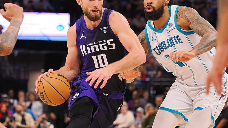 Jan 2, 2024; Sacramento, California, USA; Sacramento Kings center Domantas Sabonis (10) controls the ball against Charlotte Hornets center Nick Richards (4) during the second quarter at Golden 1 Center. Mandatory Credit: Kelley L Cox-USA TODAY Sports