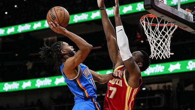 Jan 3, 2024; Atlanta, Georgia, USA; Oklahoma City Thunder guard Isaiah Joe (11) shoots against Atlanta Hawks forward Onyeka Okongwu (17) during the first half at State Farm Arena. Mandatory Credit: Dale Zanine-USA TODAY Sports