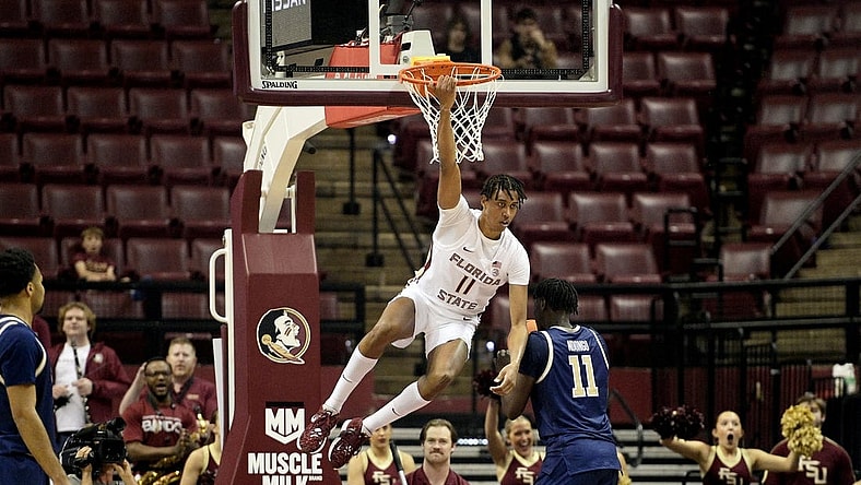 Jan 3, 2024; Tallahassee, Florida, USA; Florida State Seminoles forward Baba Miller (11) hangs on the rim after a dunk during the first half against the Georgia Tech Yellow Jackets at Donald L. Tucker Center. Mandatory Credit: Melina Myers-USA TODAY Sports