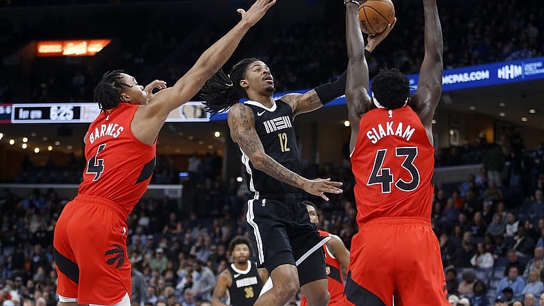 Jan 3, 2024; Memphis, Tennessee, USA; Memphis Grizzlies guard Ja Morant (12) drives to the basket between Toronto Raptors forward Scottie Barnes (4) and forward Pascal Siakam (43) during the first half at FedExForum. Mandatory Credit: Petre Thomas-USA TODAY Sports