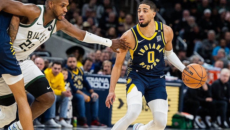 Jan 3, 2024; Indianapolis, Indiana, USA; Indiana Pacers guard Tyrese Haliburton (0) dribbles the ball while Milwaukee Bucks forward Khris Middleton (22) defends in the second half at Gainbridge Fieldhouse. Mandatory Credit: Trevor Ruszkowski-USA TODAY Sports