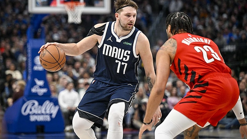 Jan 3, 2024; Dallas, Texas, USA; Dallas Mavericks guard Luka Doncic (77) looks to move the ball past Portland Trail Blazers forward Ish Wainright (23) during the second half at the American Airlines Center. Mandatory Credit: Jerome Miron-USA TODAY Sports