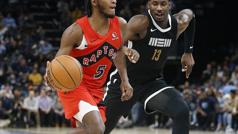 Jan 3, 2024; Memphis, Tennessee, USA; Toronto Raptors guard Immanuel Quickley (5) drives to the basket as Memphis Grizzlies forward-center Jaren Jackson Jr. (13) defends during the second half at FedExForum. Mandatory Credit: Petre Thomas-USA TODAY Sports