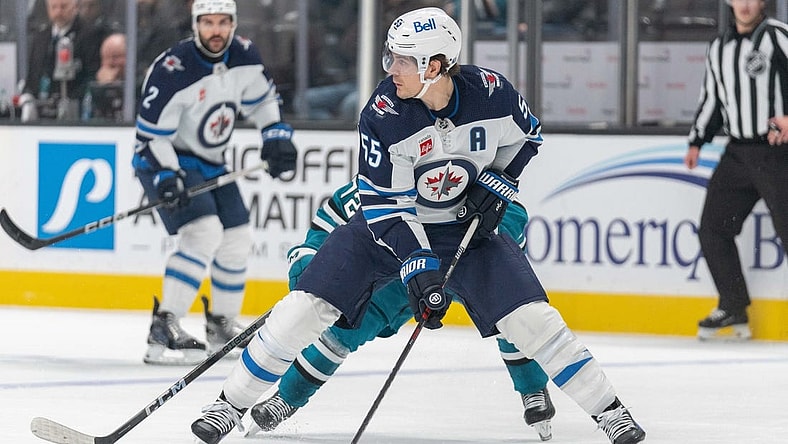 Jan 4, 2024; San Jose, California, USA;s Winnipeg Jets center Mark Scheifele (55) controls the puck during the second period against San Jose Sharks left wing William Eklund (72) at SAP Center at San Jose. Mandatory Credit: Stan Szeto-USA TODAY Sports
