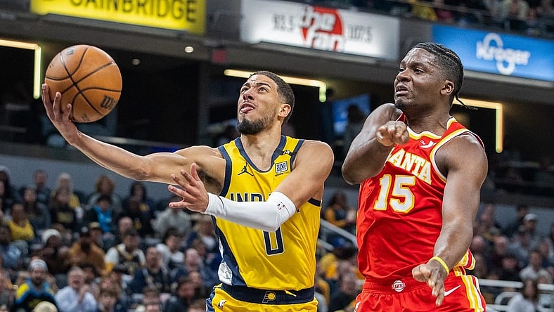 Jan 5, 2024; Indianapolis, Indiana, USA; Indiana Pacers guard Tyrese Haliburton (0) shoots the ball while Atlanta Hawks center Clint Capela (15) defends in the first quarter at Gainbridge Fieldhouse. Mandatory Credit: Trevor Ruszkowski-USA TODAY Sports