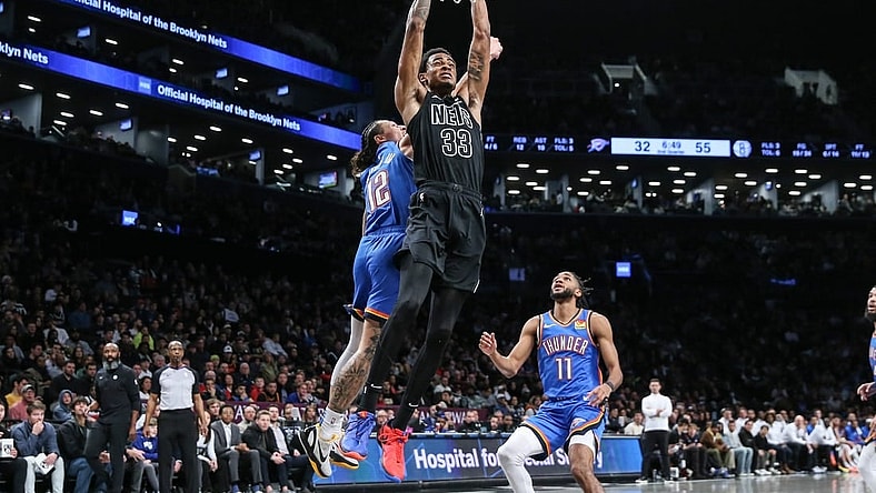 Jan 5, 2024; Brooklyn, New York, USA;  Brooklyn Nets center Nic Claxton (33) dunks past Oklahoma City Thunder forward Lindy Waters III (12) in the second quarter at Barclays Center. Mandatory Credit: Wendell Cruz-USA TODAY Sports