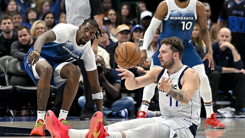 Jan 7, 2024; Dallas, Texas, USA; Dallas Mavericks guard Luka Doncic (77) passes the ball in front of Minnesota Timberwolves center Naz Reid (11) during the second quarter at the American Airlines Center. Mandatory Credit: Jerome Miron-USA TODAY Sports