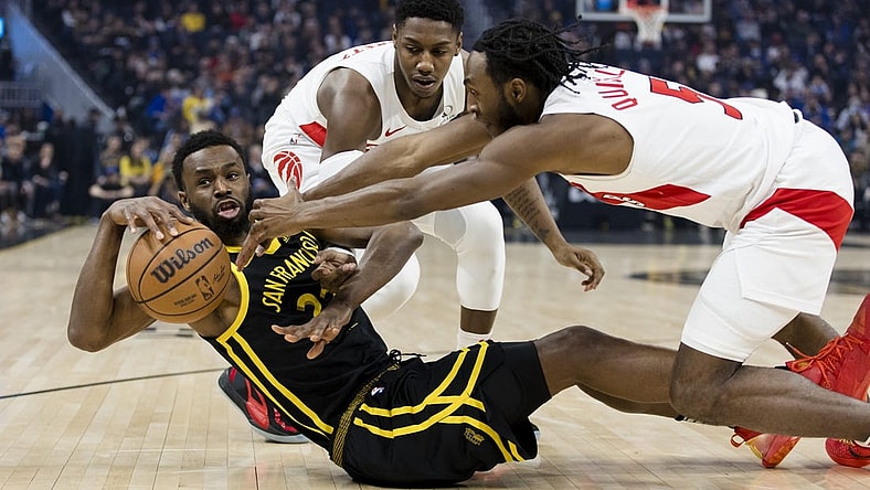 Jan 7, 2024; San Francisco, California, USA;  Golden State Warriors forward Andrew Wiggins (22) and Toronto Raptors guard Immanuel Quickley (5) and forward RJ Barrett (9) battle for possession during the first half at Chase Center. Mandatory Credit: John Hefti-USA TODAY Sports