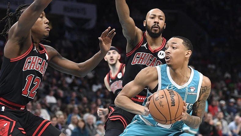 Jan 8, 2024; Charlotte, North Carolina, USA;  Charlotte Hornets guard Nick Smith Jr. (8) looks to shoot as he is defended by Chicago Bulls guard Aye Dosunmu (12) and guard Jevon Carter (5) during the first half at the Spectrum Center. Mandatory Credit: Sam Sharpe-USA TODAY Sports