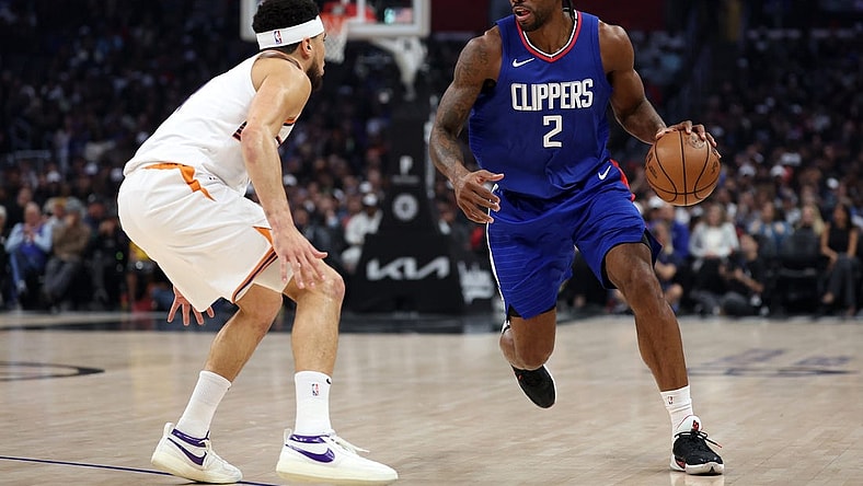Jan 8, 2024; Los Angeles, California, USA;  Los Angeles Clippers forward Kawhi Leonard (2) dribbles the ball against Phoenix Suns guard Devin Booker (1) during the first quarter at Crypto.com Arena. Mandatory Credit: Kiyoshi Mio-USA TODAY Sports