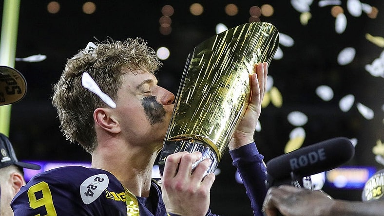 Michigan quarterback J.J. McCarthy kisses the championship trophy to celebrate the Wolverines' 34-13 win over Washington in the national championship game at NRG Stadium in Houston on Monday, Jan. 8, 2024.