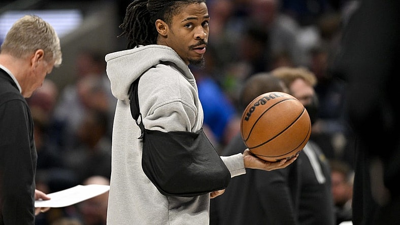 Jan 9, 2024; Dallas, Texas, USA; Memphis Grizzlies guard Ja Morant (12) looks on while wearing his arm in a sling during a time stoppage in the first quarter of the game between the Dallas Mavericks and the Memphis Grizzlies at the American Airlines Center. Mandatory Credit: Jerome Miron-USA TODAY Sports