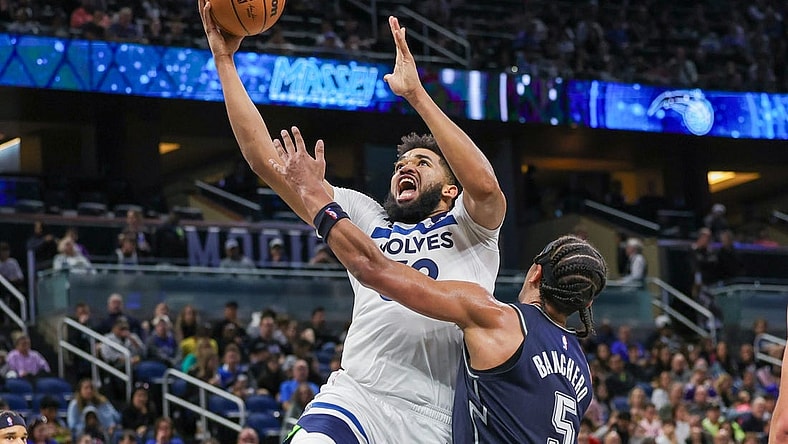 Jan 9, 2024; Orlando, Florida, USA; Minnesota Timberwolves center Karl-Anthony Towns (32) goes to the basket against Orlando Magic forward Paolo Banchero (5) during the second quarter at KIA Center. Mandatory Credit: Mike Watters-USA TODAY Sports