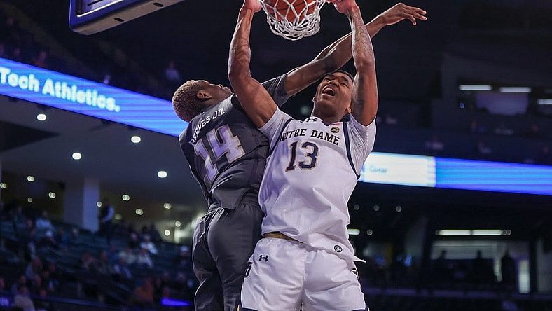 Jan 9, 2024; Atlanta, Georgia, USA; Notre Dame Fighting Irish forward Tae Davis (13) dunks past Georgia Tech Yellow Jackets guard Kowacie Reeves Jr. (14) in the first half at McCamish Pavilion. Mandatory Credit: Brett Davis-USA TODAY Sports