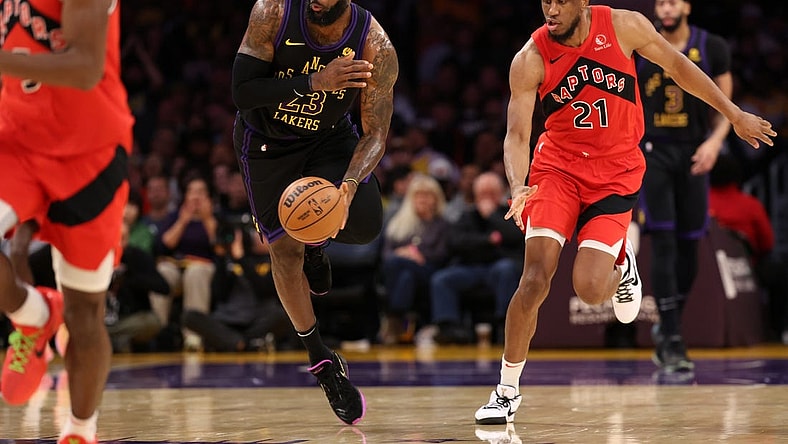 Jan 9, 2024; Los Angeles, California, USA; Los Angeles Lakers forward LeBron James (23) picks up a loose ball ahead of Toronto Raptors forward Thaddeus Young (21) during the second quarter at Crypto.com Arena. Mandatory Credit: Kiyoshi Mio-USA TODAY Sports